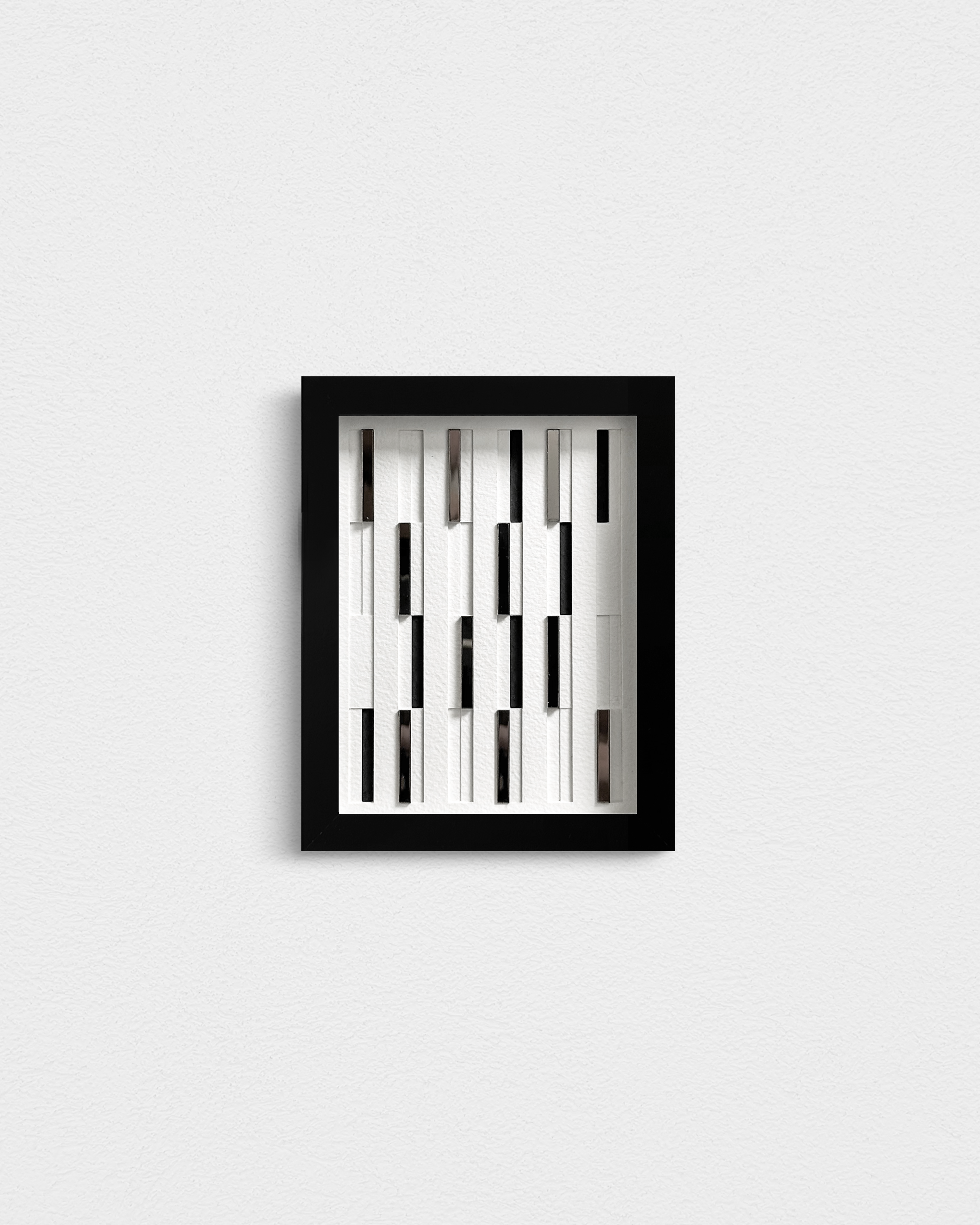 Modern art piece with layered paper relief and mirrors, reflecting a dynamic, ever-changing light.